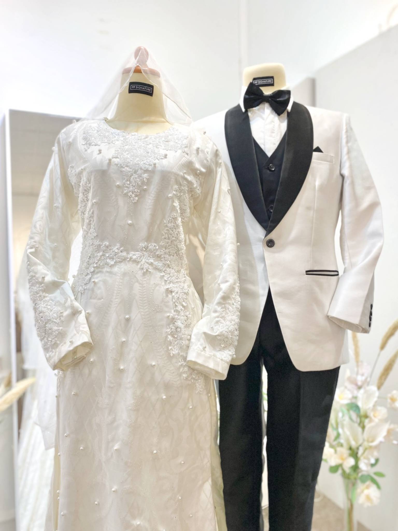 Luxurious off-white ballgown with detachable trail. Perfect for glamorous Malay weddings. Includes groom's suit. Rent now!